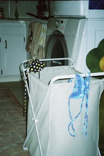 a laundry basket with a teddy bear sitting on top of it