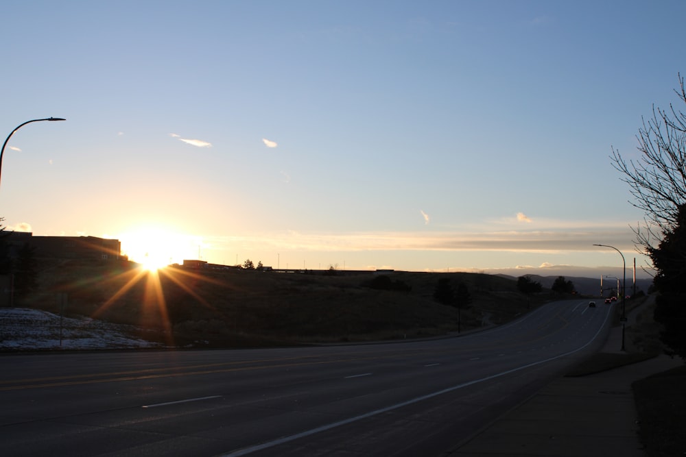 the sun is setting over a city street