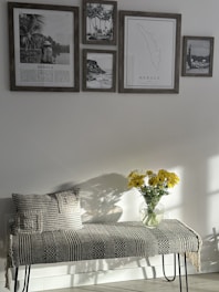 a bench with a vase of yellow flowers on it