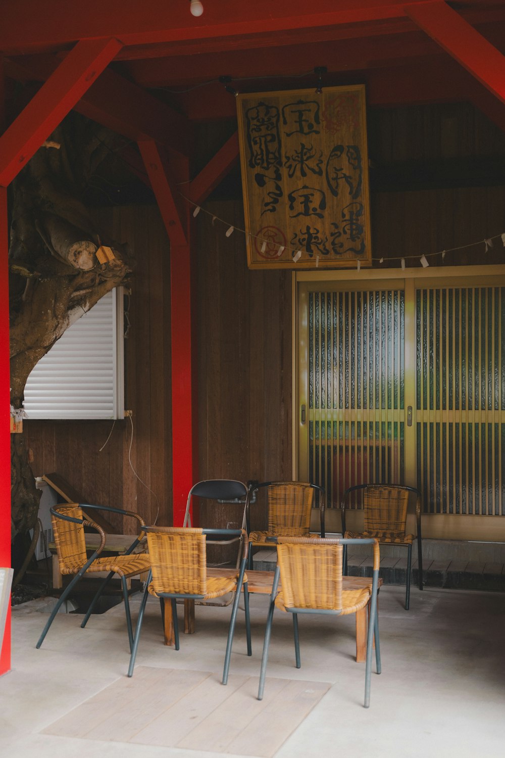 a group of wooden chairs sitting under a red roof