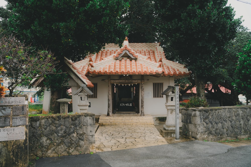 a small white building with a red roof