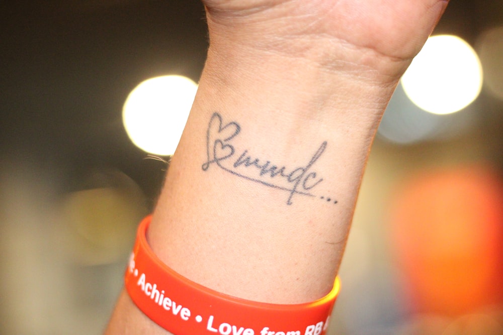 a wrist tattoo with a message written on it