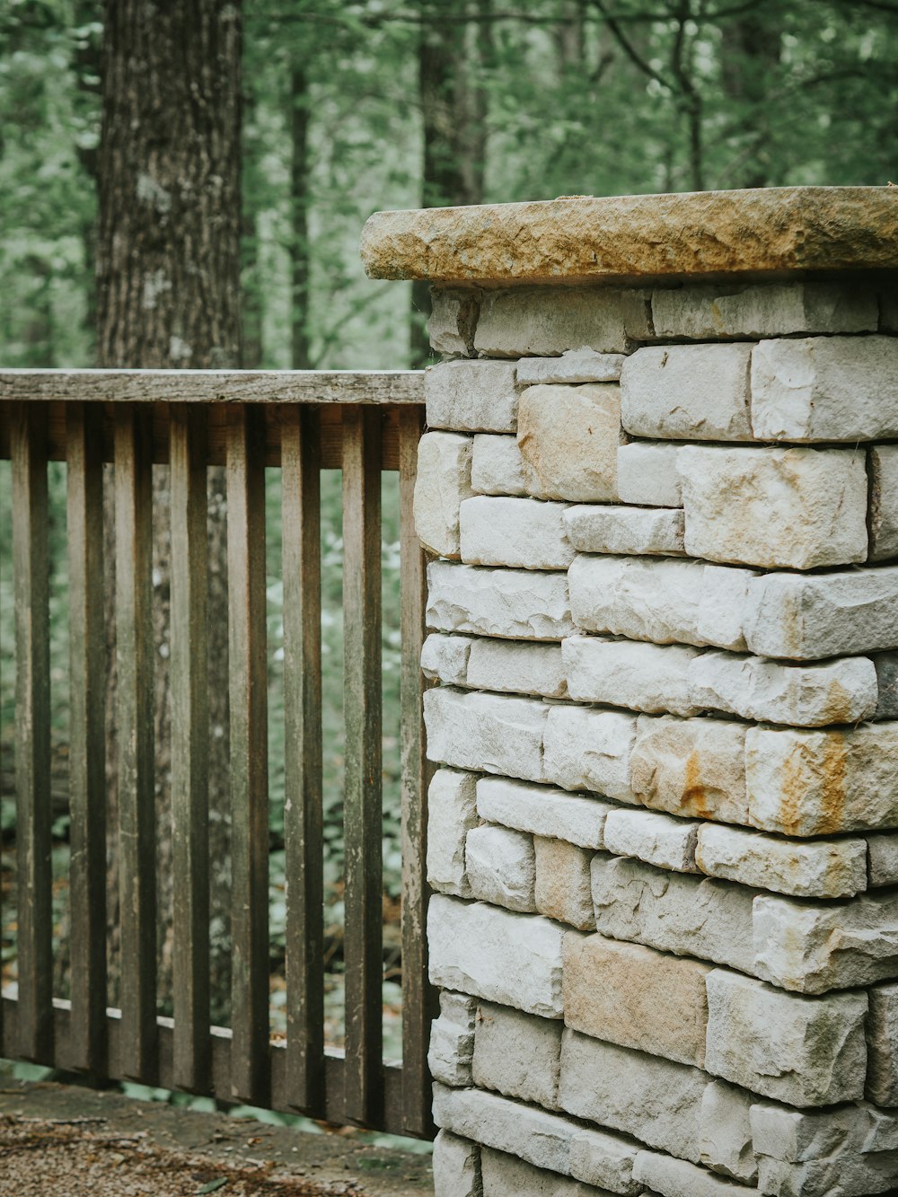 a wooden bench sitting next to a stone wall