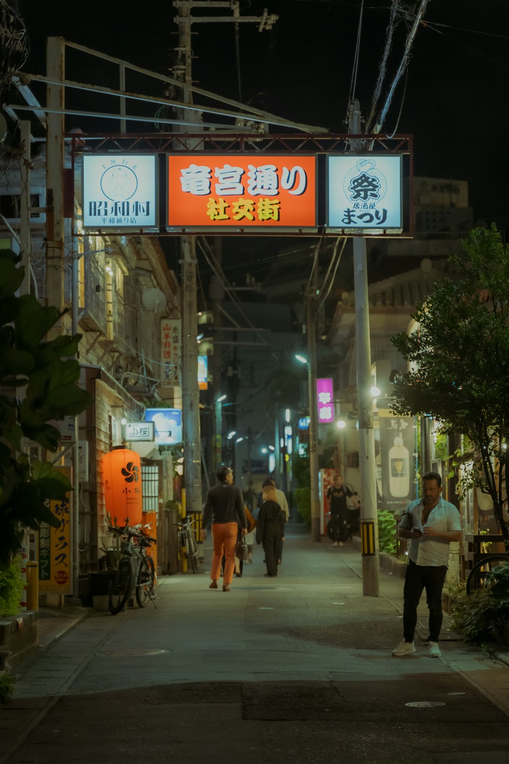 a group of people walking down a street at night