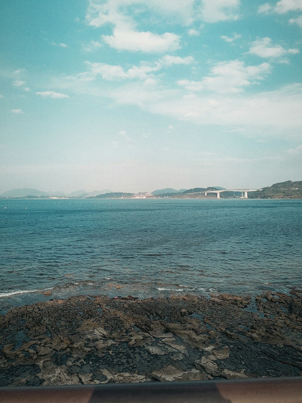 a body of water with a bridge in the background