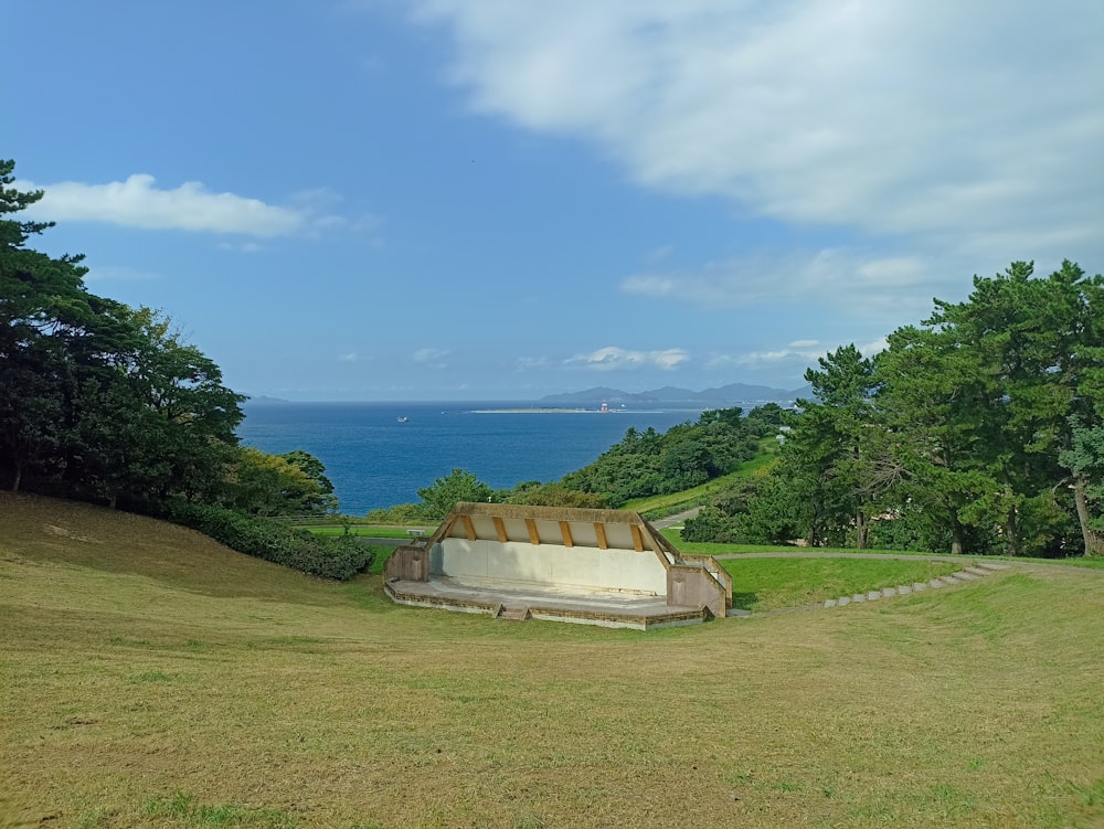 a bench sitting on top of a lush green hillside