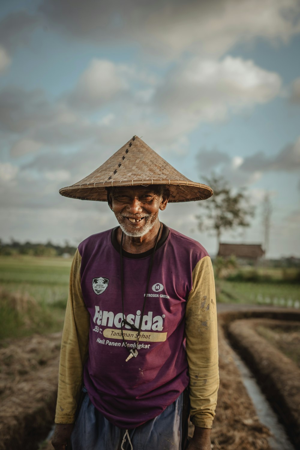 a man wearing a straw hat standing in a field