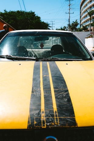 a yellow car with a black stripe painted on it