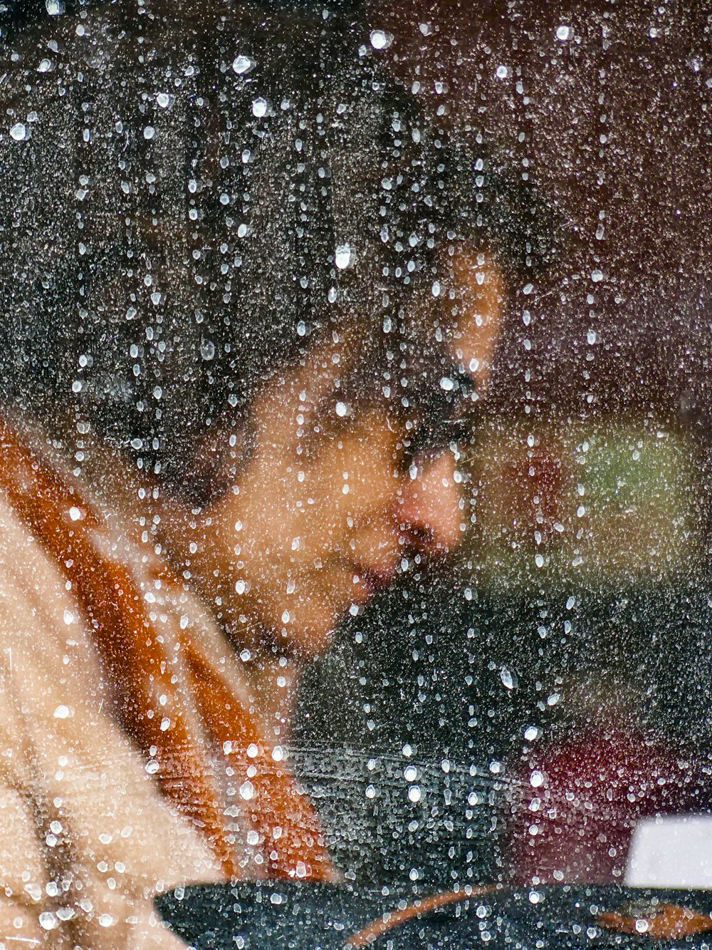 Eine Frau, die im Regen auf ihren Laptop schaut