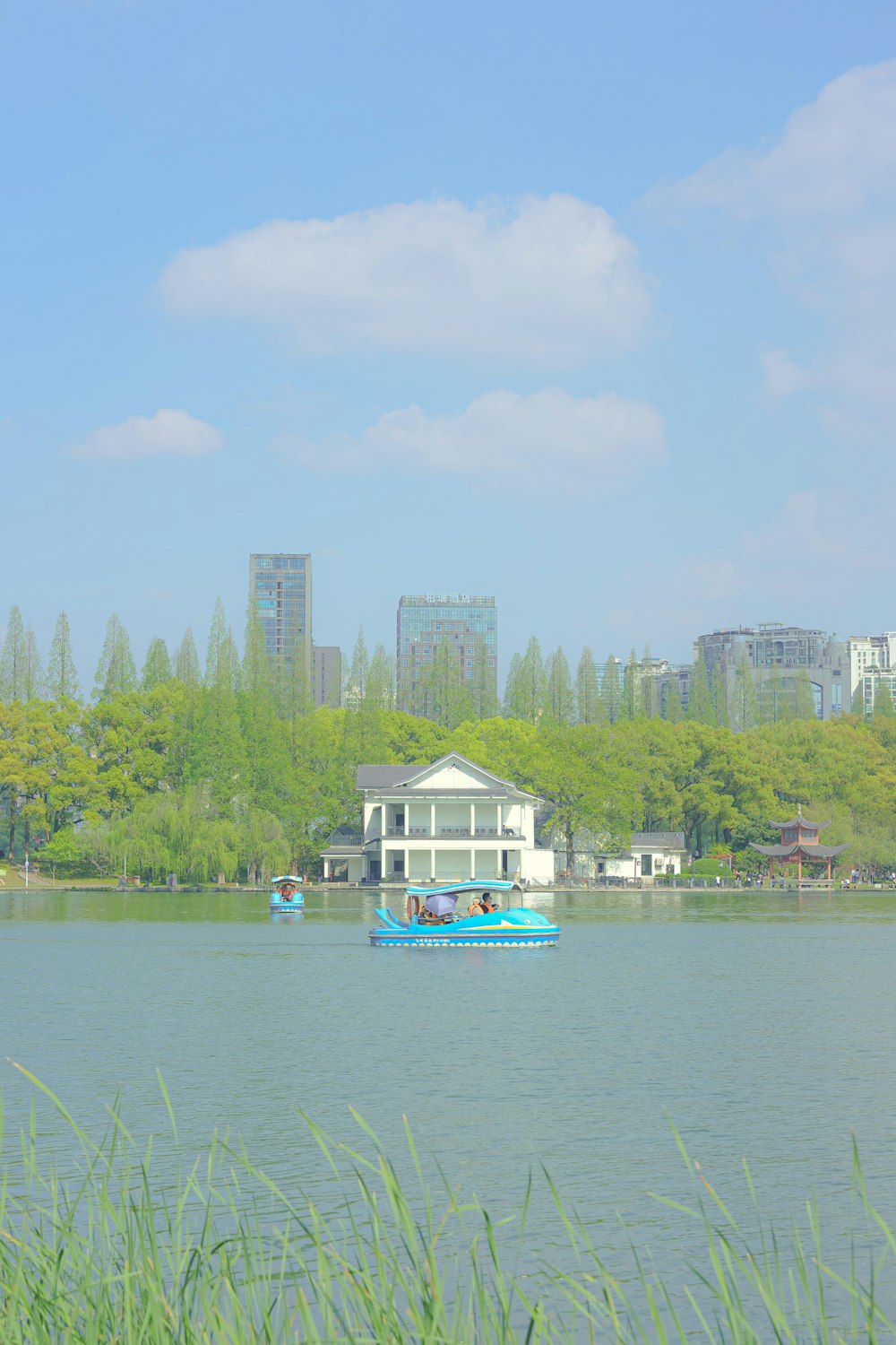 a boat floating on top of a lake next to tall buildings