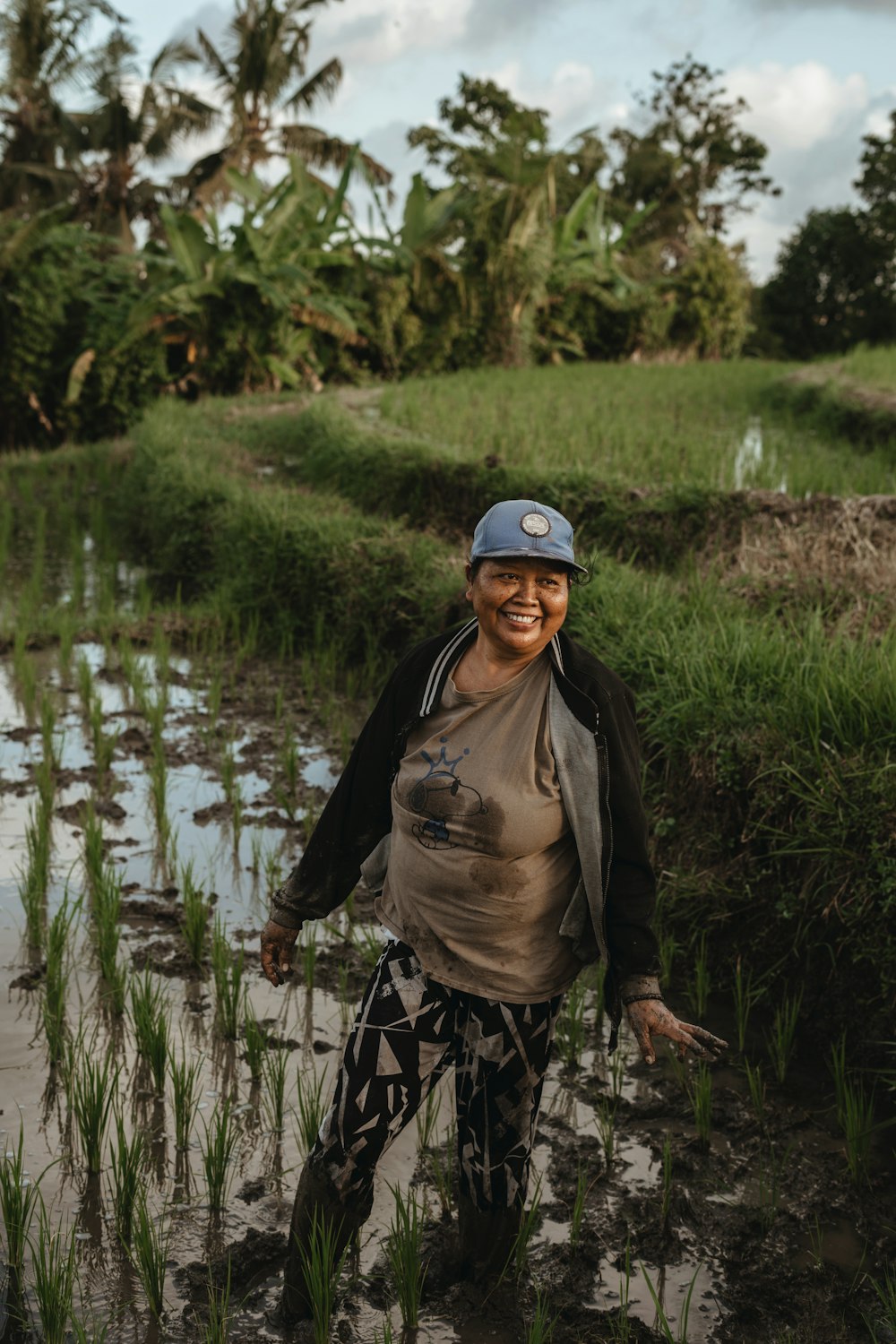 a smiling woman standing in a field of grass