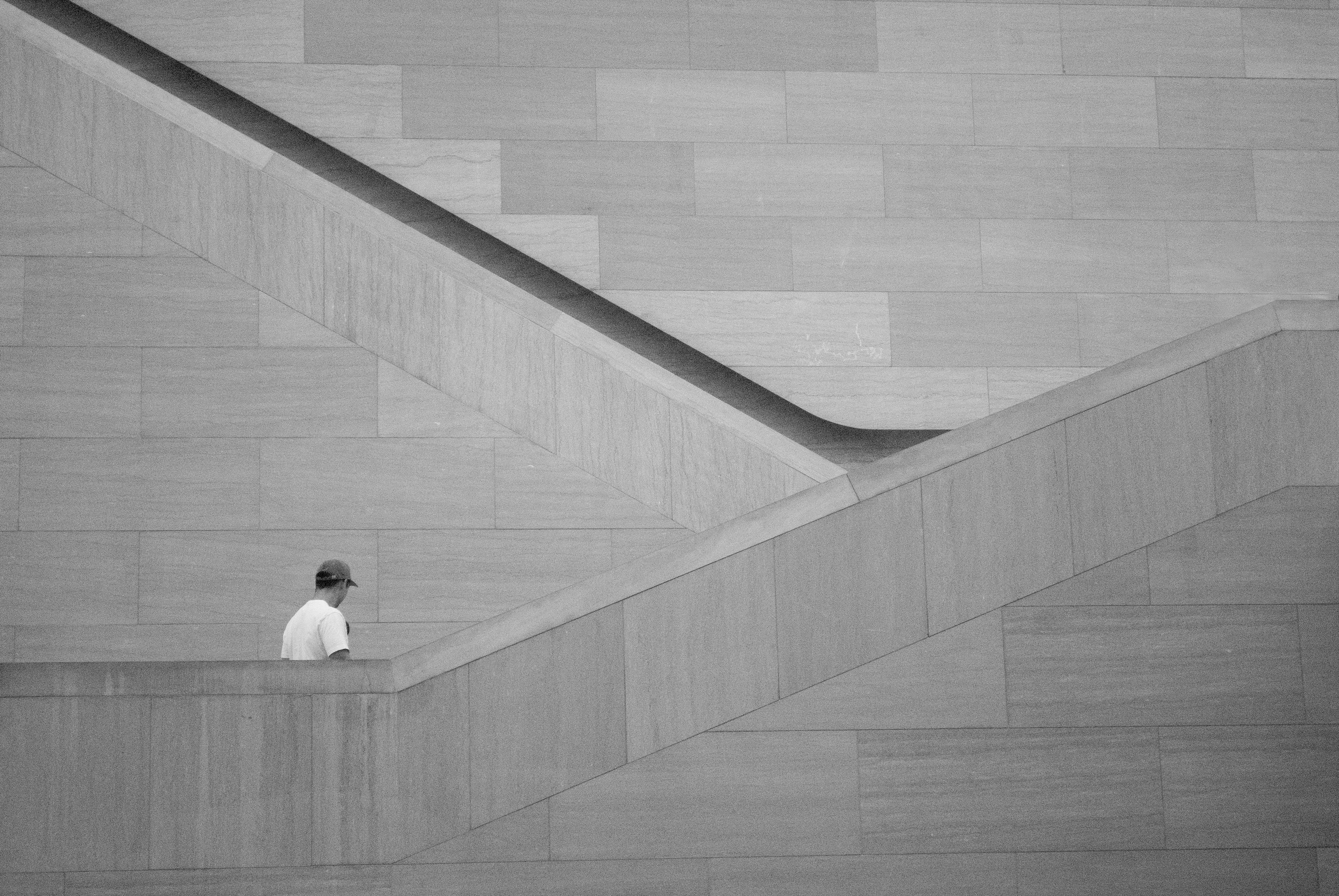 a person standing on a ledge in front of a building