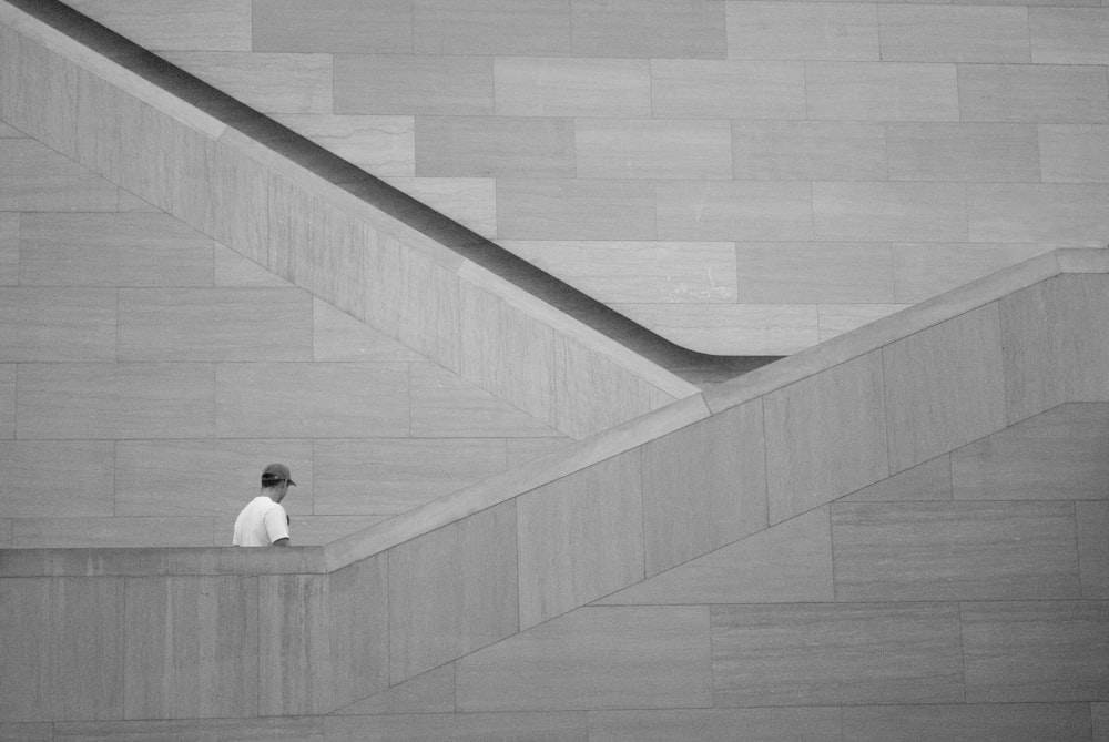 a person standing on a ledge in front of a building