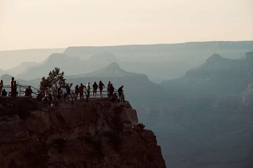 a group of people standing on the edge of a cliff