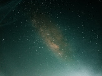 a person standing on a hill under a night sky