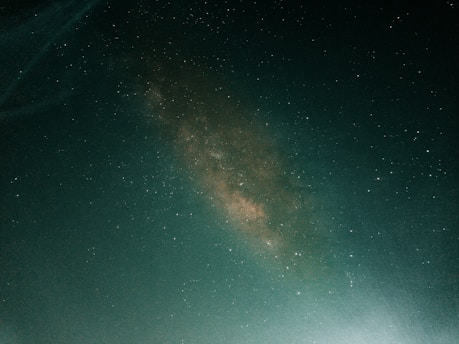 a person standing on a hill under a night sky