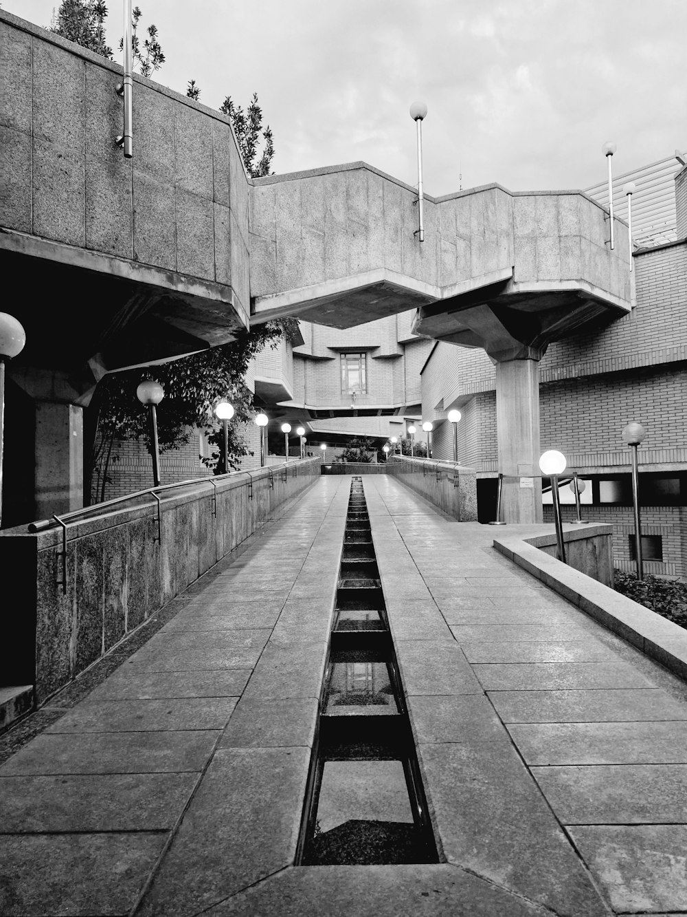 a black and white photo of a walkway in a building