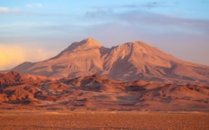 a mountain range with a few clouds in the sky