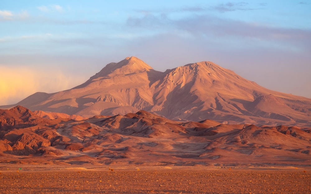 a mountain range with a few clouds in the sky