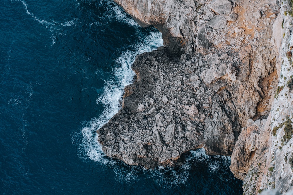 an aerial view of a rocky cliff and the ocean