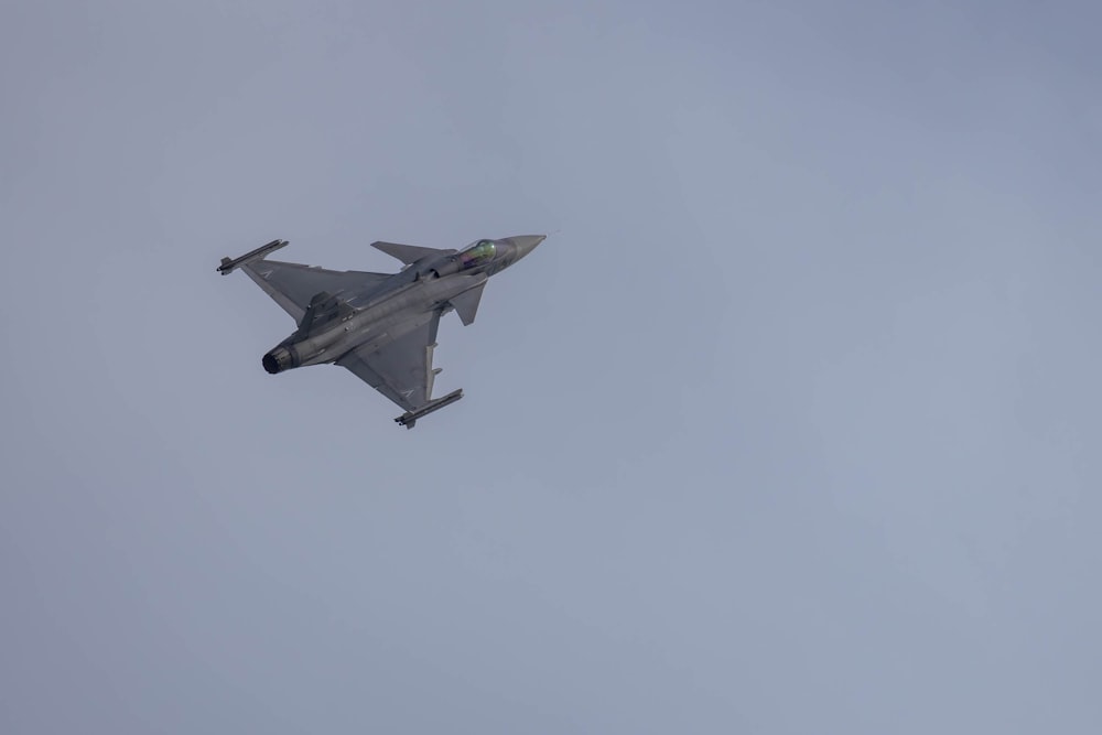 a fighter jet flying through a cloudy sky