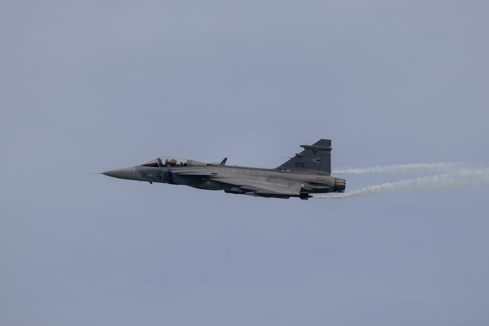 a fighter jet flying through a cloudy sky