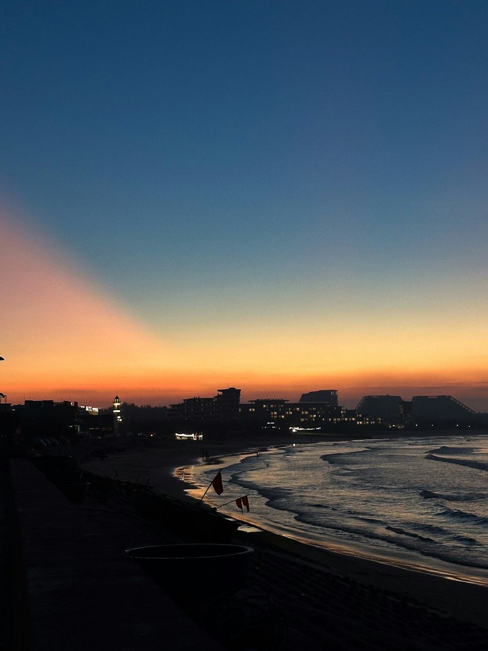 the sun is setting over the ocean and a beach