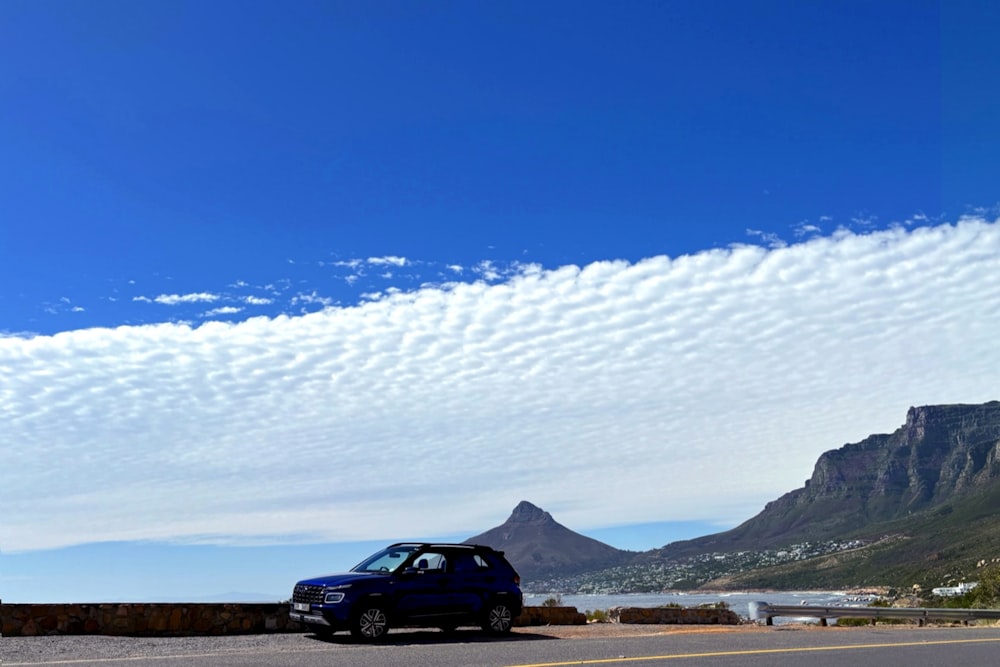 a blue car parked on the side of a road