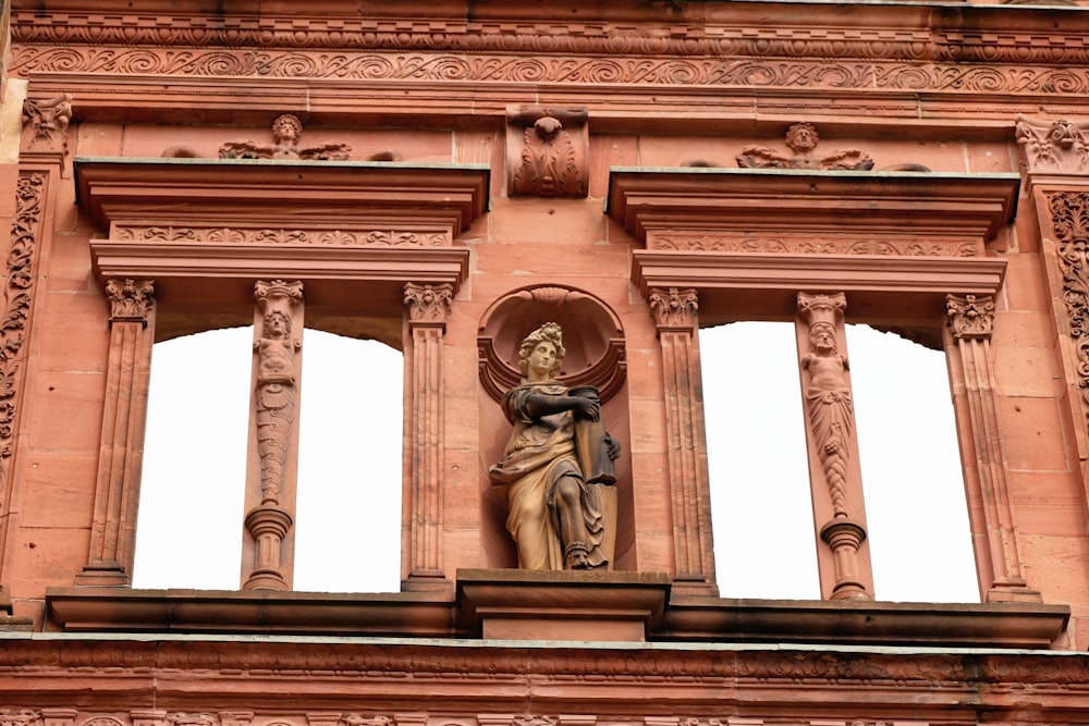a statue of a woman on a balcony of a building