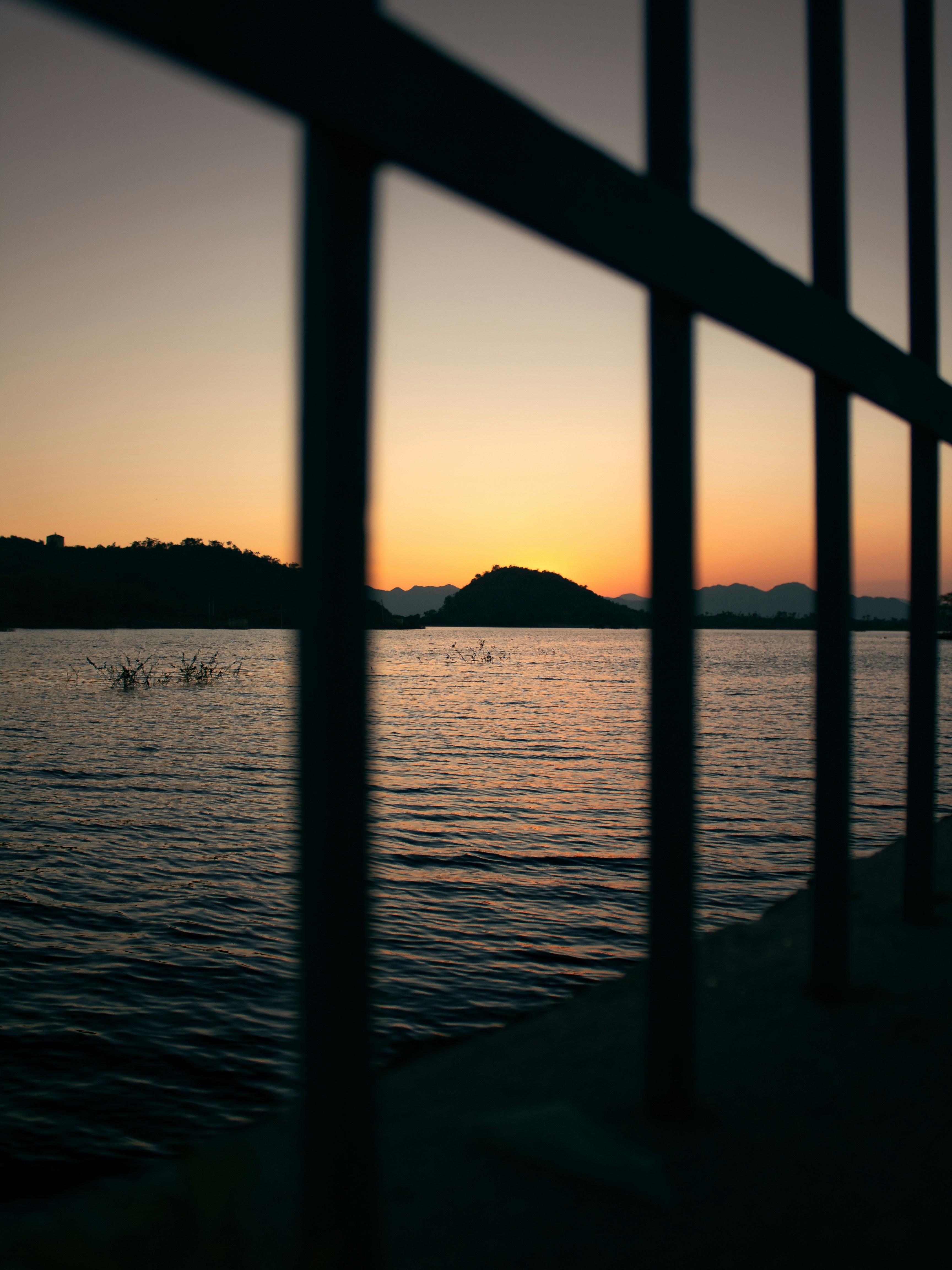 a view of a body of water through a fence