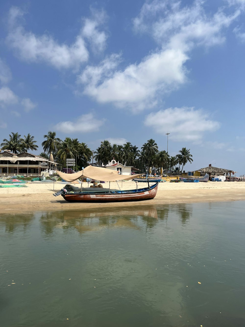 a boat sitting on top of a sandy beach