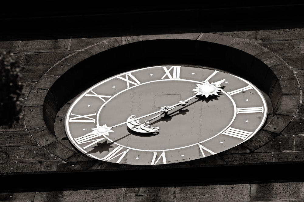 a black and white photo of a clock on a building