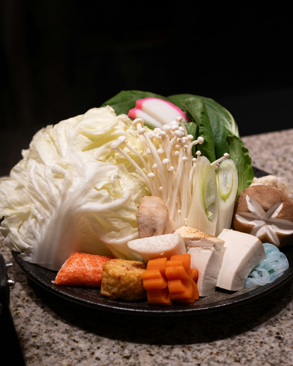 a plate of vegetables and cheese on a table