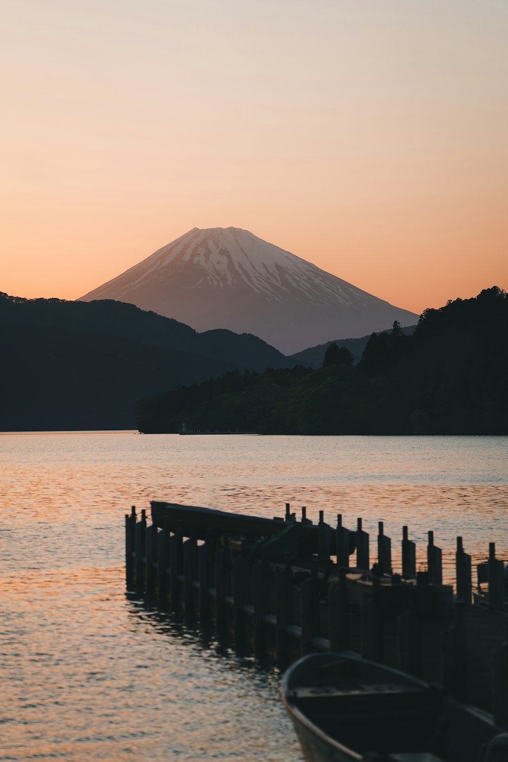 a boat sitting on top of a lake next to a mountain