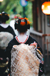 a woman in a kimono walking down a street