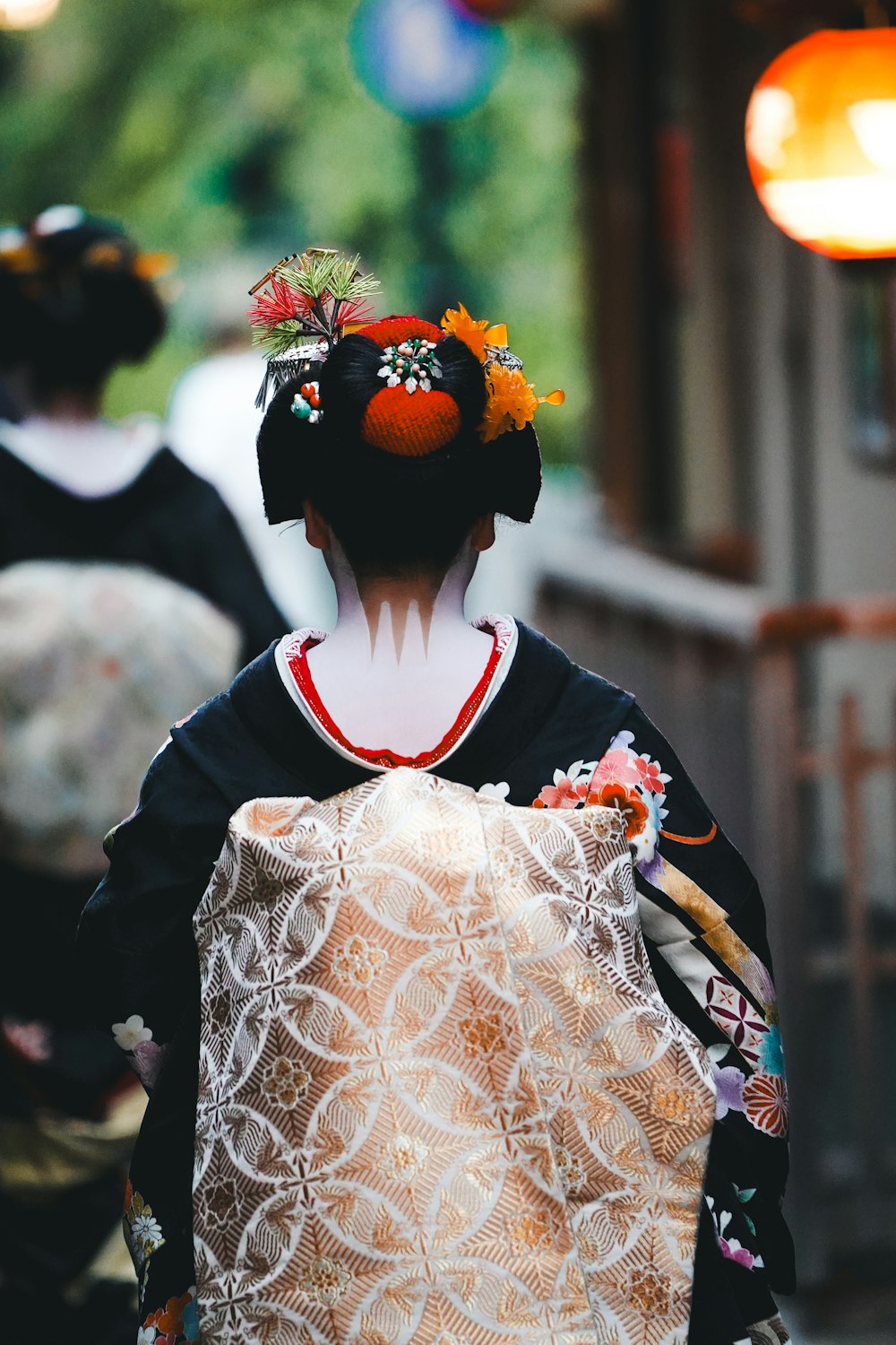 a woman in a kimono walking down a street