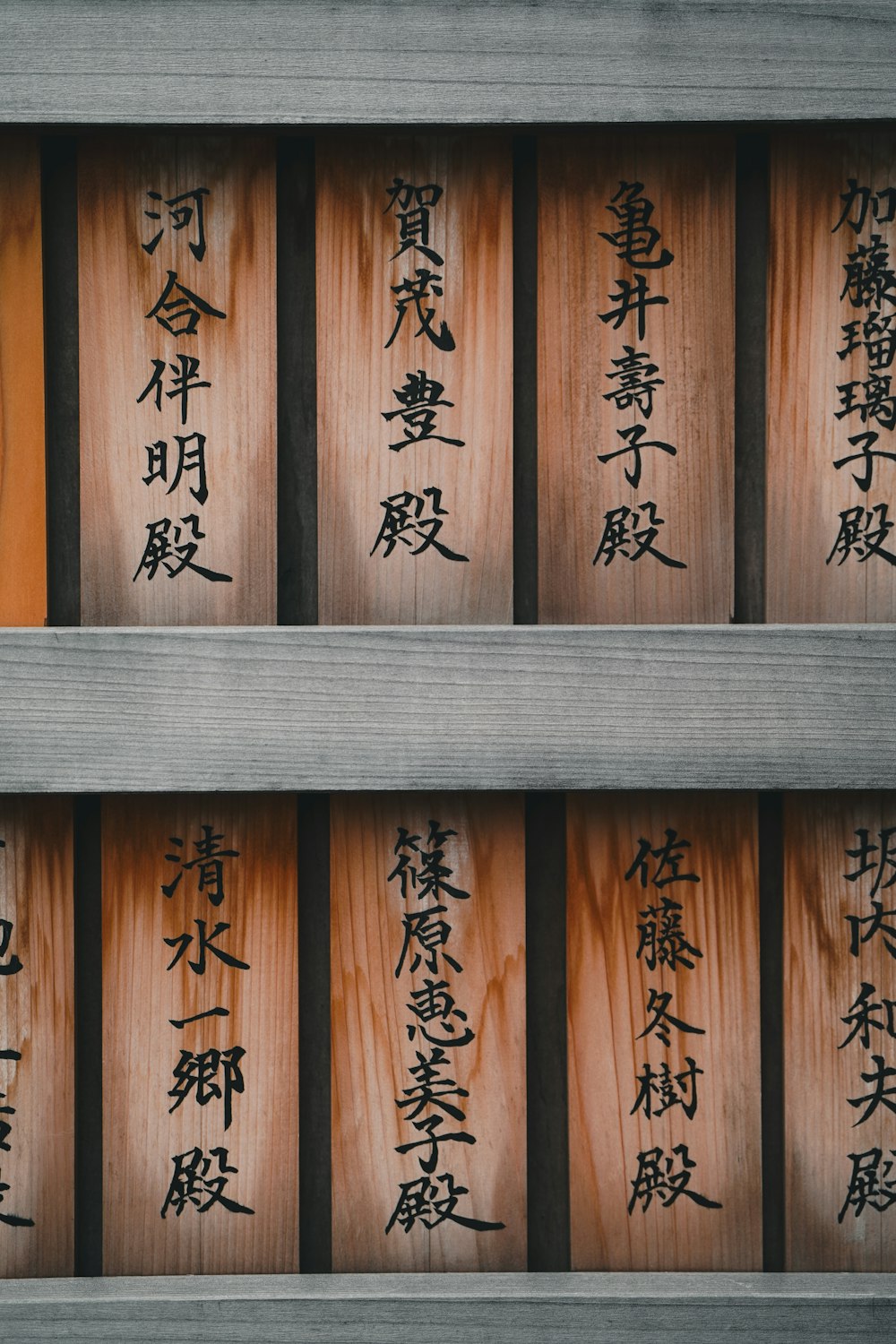 a row of wooden shelves with asian writing on them