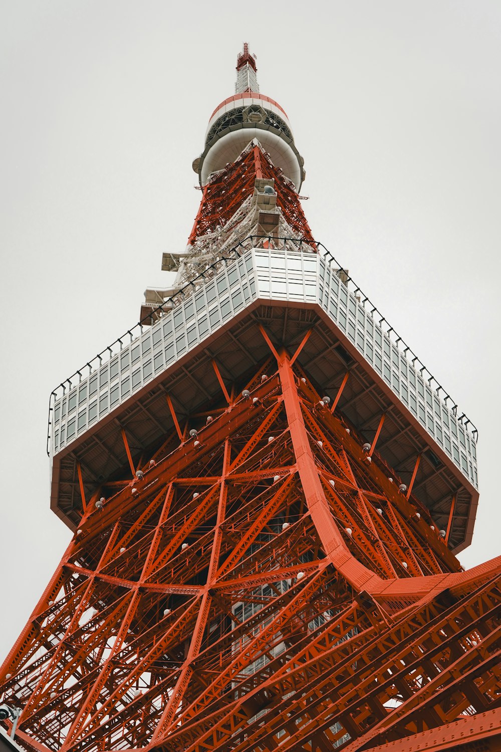 a very tall red tower with a clock on it's side