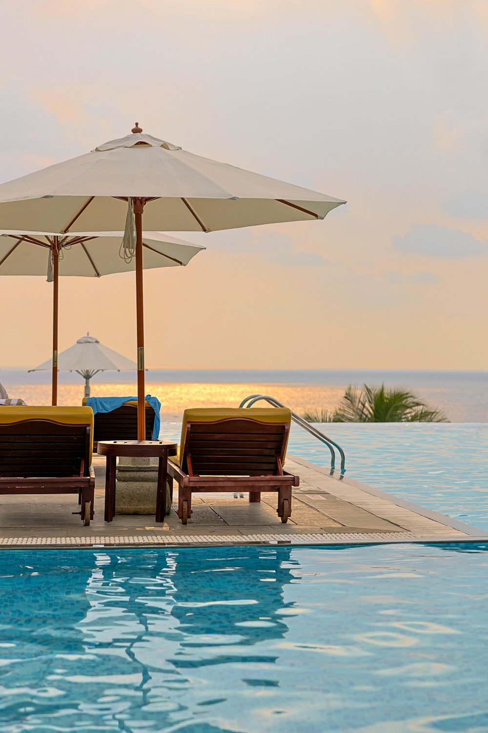 a couple of lawn chairs sitting next to a swimming pool