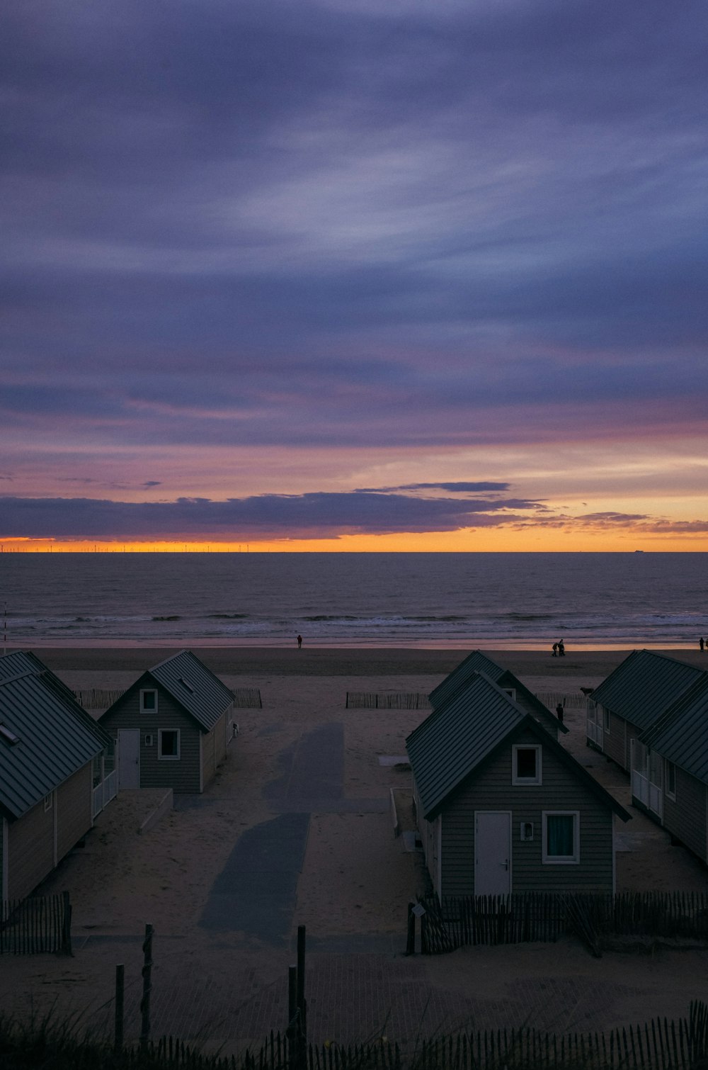 un groupe de maisons situées au sommet d’une plage de sable