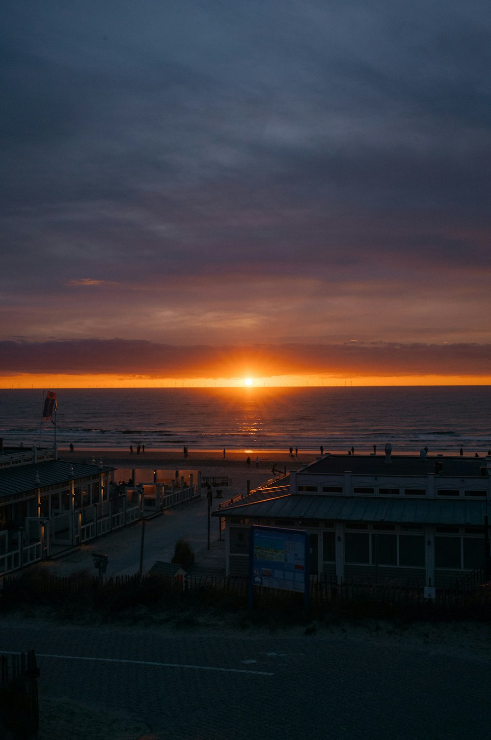 the sun is setting over the ocean at the beach