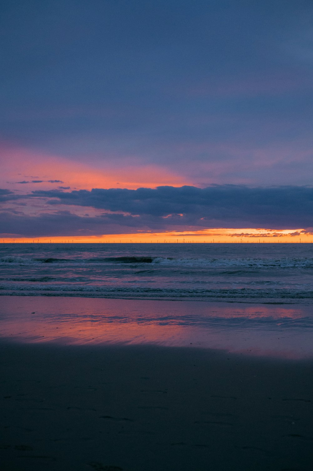 a person walking on the beach at sunset