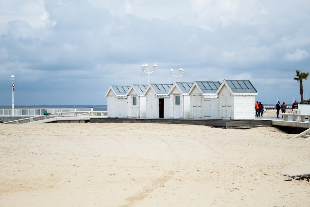 une rangée de cabines de plage au sommet d’une plage de sable