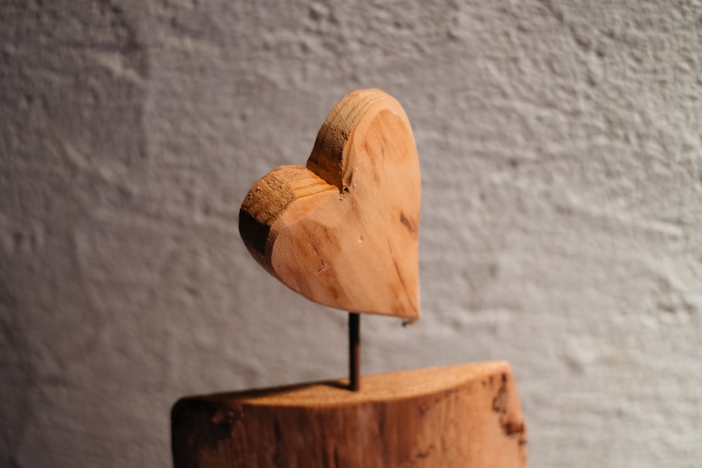 a wooden heart on top of a piece of wood
