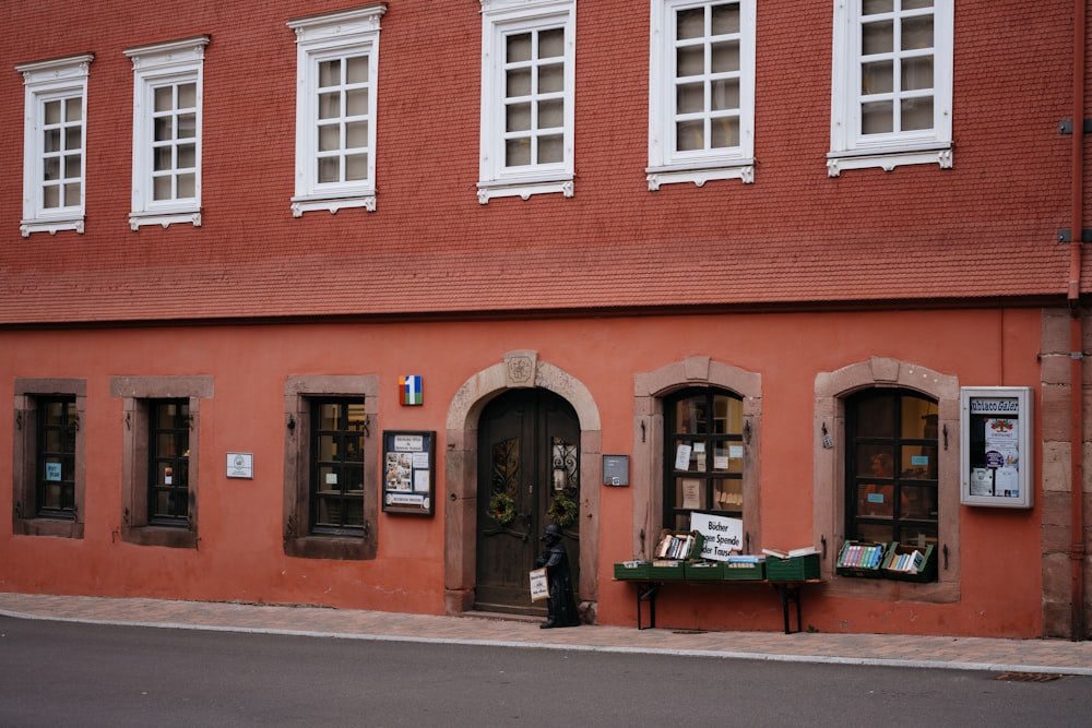 a red brick building with a green table outside of it
