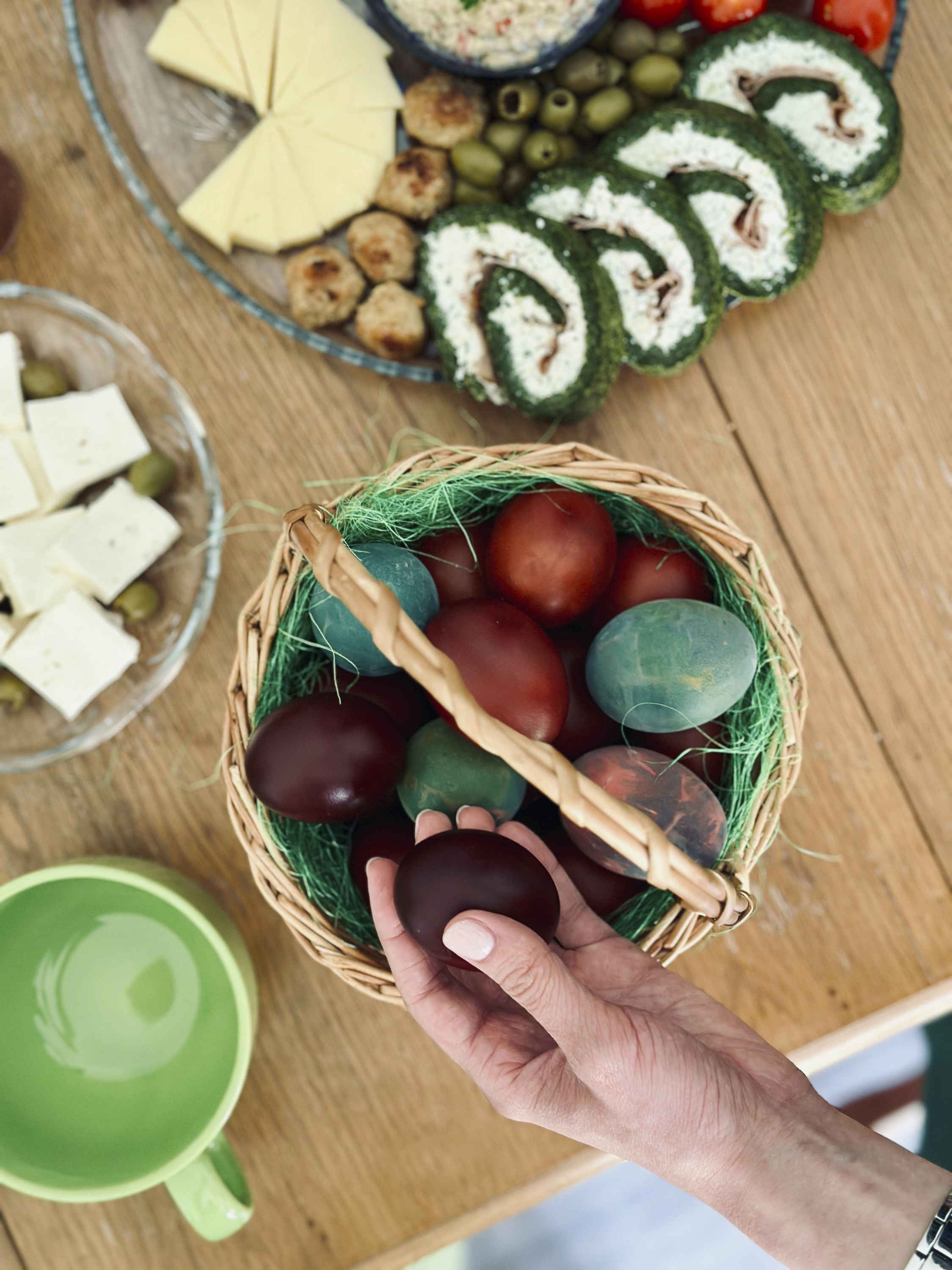 a person holding an egg in front of a basket of food