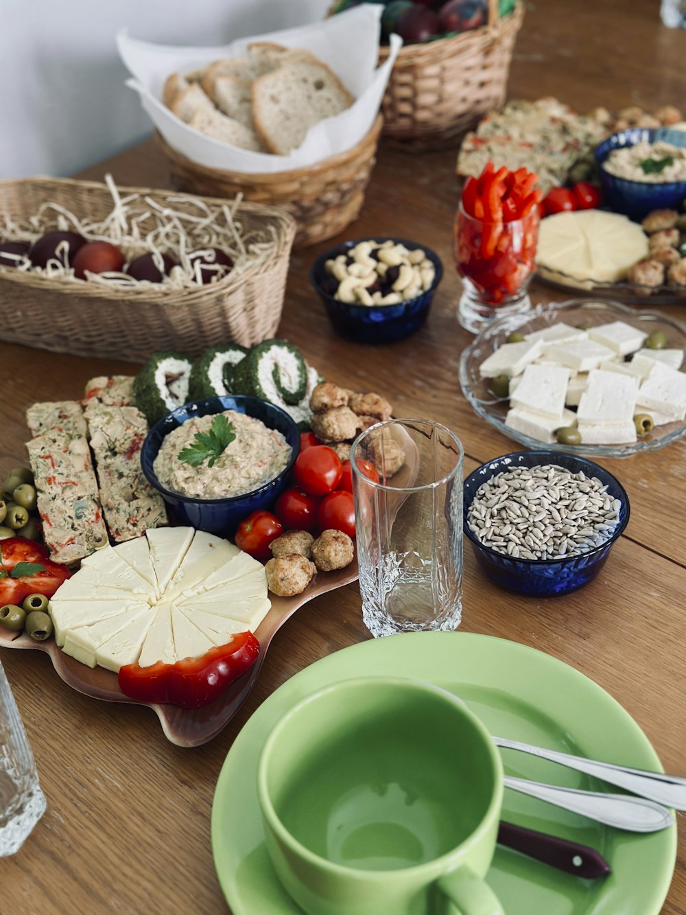 a wooden table topped with plates and bowls of food