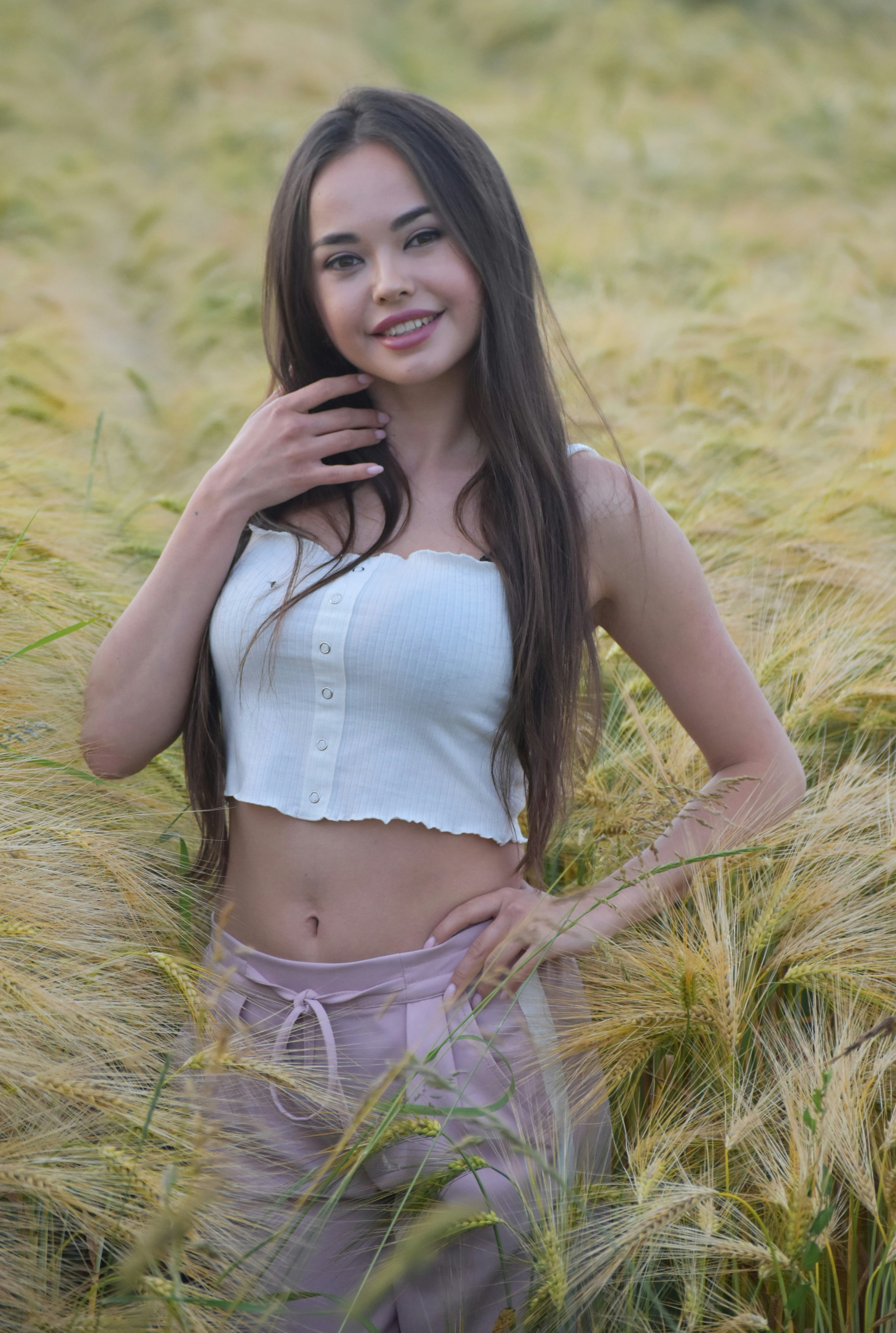 a woman standing in a field of tall grass
