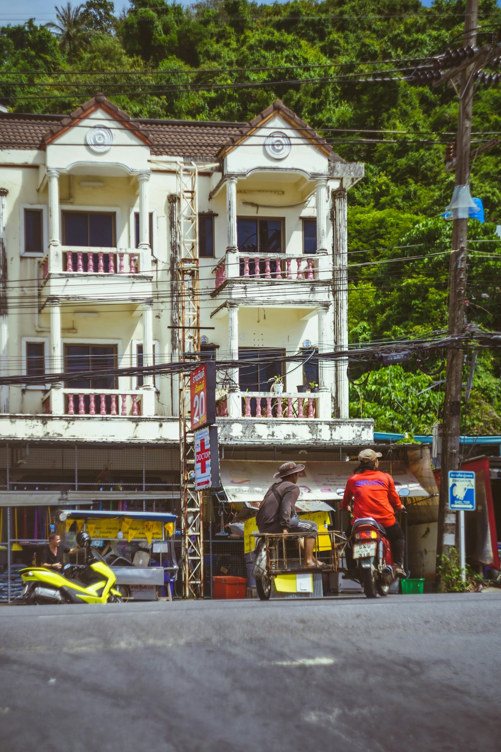 a man on a moped standing in front of a building