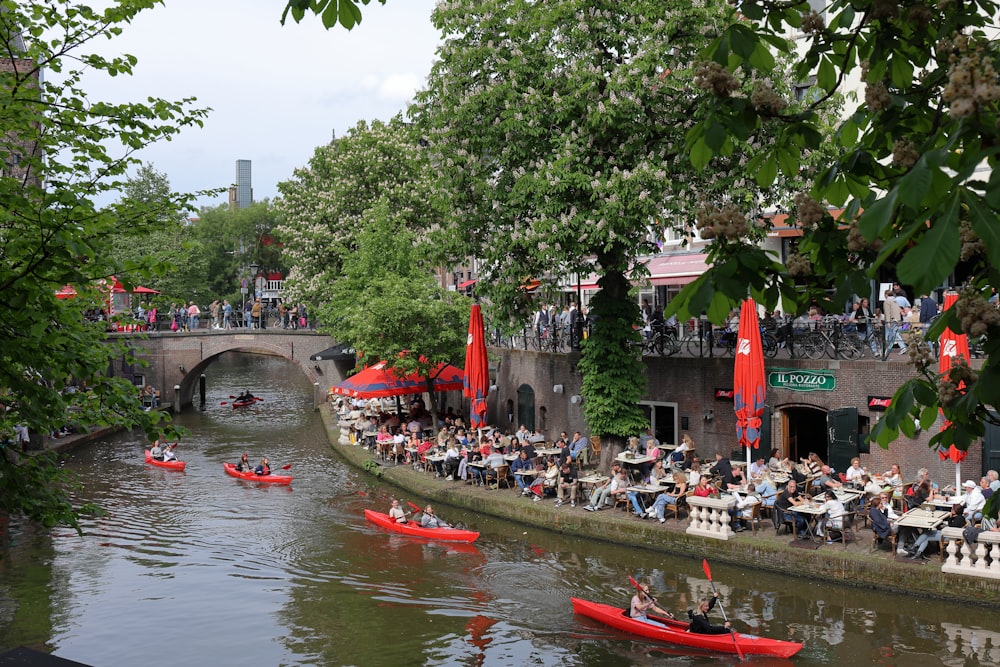 a group of people riding red canoes down a river